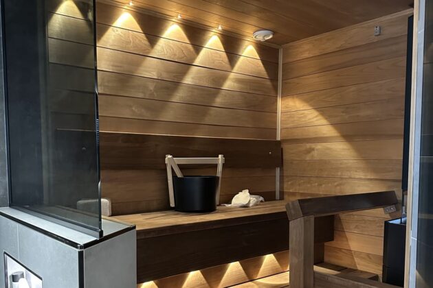 saunaremontti Kuvassa on vastaremontoitu sauna, jossa on kaunis valaistus ja lasiseinä.